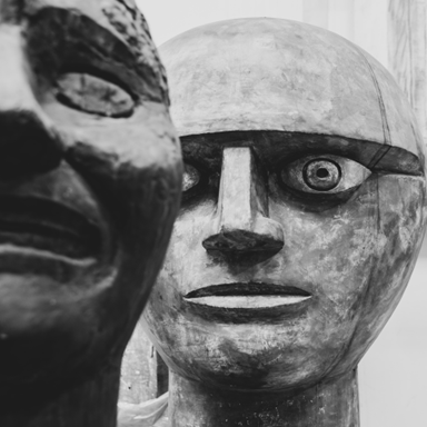Close-up of abstract stone sculptures with large circular eyes