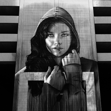 Black-and-white mural portrait of a hooded woman framed by bold geometric shapes